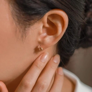 Minimalist gold balloon dog stud earring worn by a model for a chic daily style