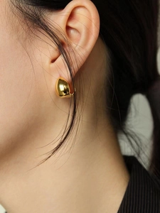 Polished gold waterdrop earrings in minimalist 925 silver style on female model