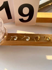 Detailed view of 925 sterling silver bow earrings in polished gold and silver finishes