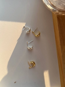 Polished silver and gold C-shape stud earrings set displayed in natural light
