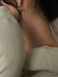 Boucles d'oreilles chien ballon en argent portées par un mannequin au style artistique