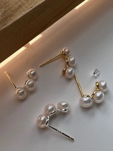 Detailed close-up of 925 sterling silver stamp on minimalist triple pearl stud earrings