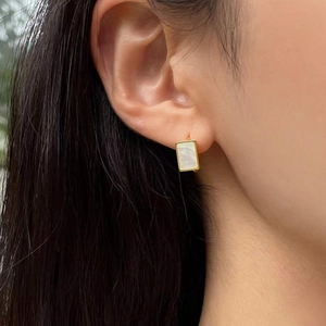 Boucles d'oreilles carrées en argent 925 doré avec nacre blanche naturelle sur l'oreille