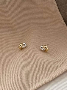 Macro shot of 925 sterling silver twisted knot earrings in dual-tone gold and silver