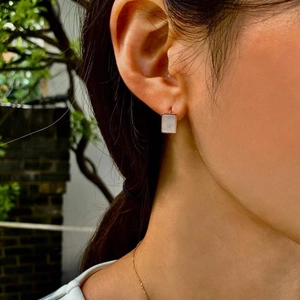 Boucles d'oreilles carrées en nacre et or rose portées par un mannequin