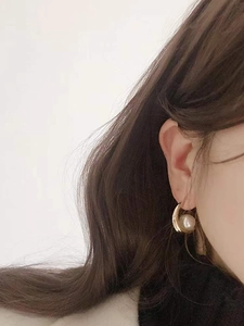 Elegant S925 sterling silver gold-plated hoop earrings with round white pearls on a model