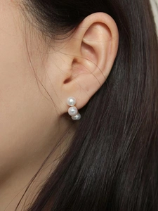 Elegant 925 silver stud earrings with three vertical white pearls on model side view