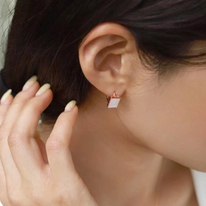 Gros plan de boucles d'oreilles carrées en argent 925 avec nacre portées par un mannequin