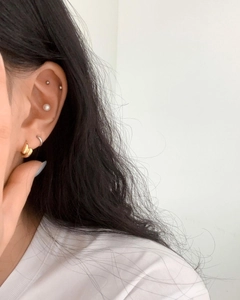 Close-up of 925 silver and gold-plated stud earrings and hoops set on ear