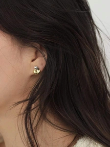 Minimalist 925 sterling silver heart earrings with two-tone gold and silver finish on model