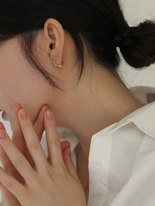 Minimalist textured gold hoop earring displayed on a model for an elegant side profile view