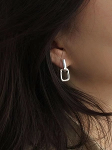 Close-up of minimalist 925 sterling silver U-shaped geometric earrings worn on ear