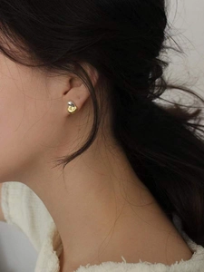 Detail of 925 sterling silver two-tone earrings with organic gold and silver finish