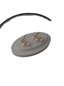 Elegant 925 sterling silver stud earrings featuring three white pearls in a golden setting