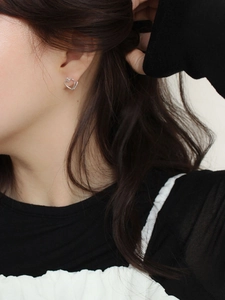 Elegant 925 sterling silver hollow heart stud earrings worn by a female model