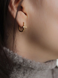 Boucles d'oreilles en argent 925 doré en forme de U avec trois zircons sur modèle