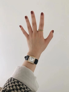 Classic rectangle gold watch with black leather strap and green gemstone ring