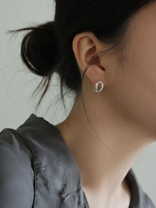 Gros plan de boucles d'oreilles créoles en argent 925 avec texture torsadée sur mannequin