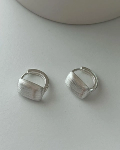 Detailed macro view of 925 sterling silver earrings with textured brushed metal finish