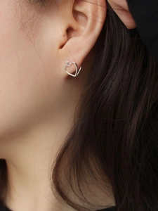 Minimalist 925 sterling silver hollow heart stud earrings for women on model ear