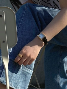 Elegant gold square watch with black leather strap and green gemstone ring set