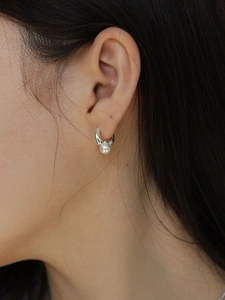 Minimalist silver hoop earrings with elegant pearl pendant worn by female model