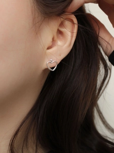 Minimalist 925 sterling silver hollow heart stud earrings worn by a model