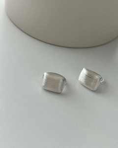 Macro shot of rectangular brushed 925 sterling silver earrings with matte texture