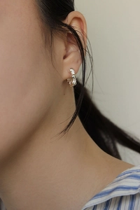 Detailed view of S925 sterling silver hoop earrings with pavé zircon beads on model