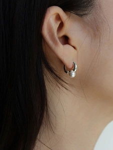 Elegant pearl drop hoop earrings in polished silver finish shown on a female model