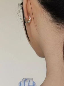 Minimalist 925 sterling silver hoop earrings with a beaded texture on a model