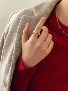 Set di anelli a catena dorata e collana abbinati a un outfit invernale a strati