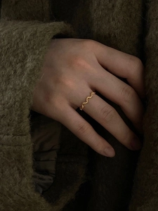 Eleganter 925 Sterling Silber Goldwellenring an der Hand eines Models auf Stoffhintergrund