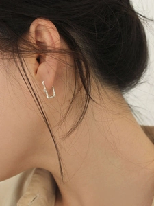 Orecchini a cerchio rettangolari in argento 925 con texture irregolare indossati dal modello