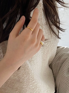 Macro detail of irregular textured gold ring and two-tone quilted pattern band