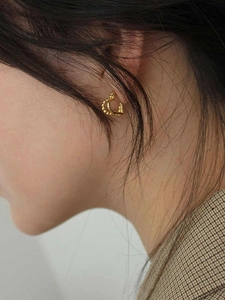 Eleganti orecchini a cuore in argento 925 dorato indossati da una modella con stile minimale