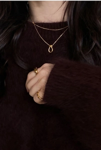 Collier nœud minimaliste en argent 925 avec bagues dorées assorties sur un modèle