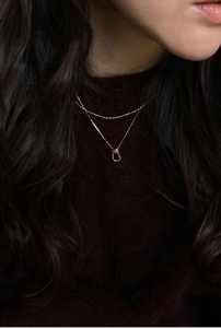 Élégant collier nœud en argent 925 finition dorée sur un pull à col roulé foncé