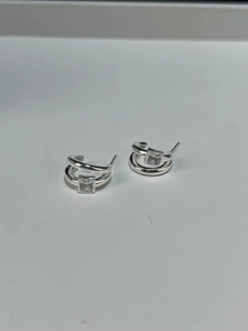 Close-up of 925 sterling silver double-layered C-shape earrings with square zircon stone