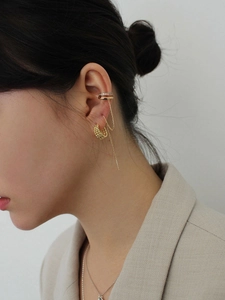 Detail of 925 silver layered twist hoop earring with diamond ear cuff and chain