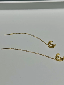 Macro view of gold-plated tassel ear cuff and long chain earring with pavé zircon