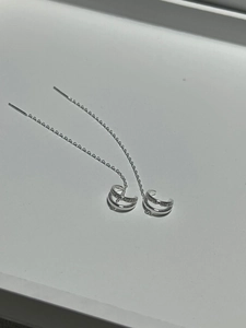 Macro view of silver ear cuff tassel earrings with micro-set zircons on curved lines