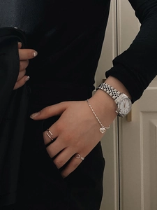 Silver bamboo-style adjustable ring and heart charm bracelet set on model wrist