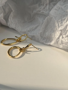 Minimalist gold double-hoop knotted earrings with a high-polished metallic finish