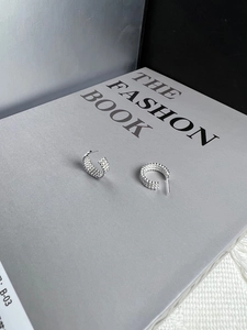 Detailed view of 925 silver French vintage twisted hoop earrings on a fashion book