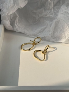 Macro shot of 925 silver golden double oval knot earrings with polished metal finish