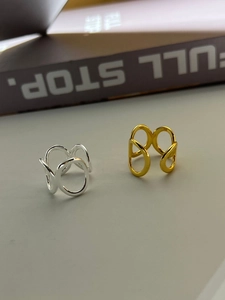 Close-up of minimalist 925 sterling silver interlocking oval rings in gold and silver