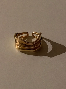 Detailed close-up of a gold double-layer irregular wavy open ring with modern texture
