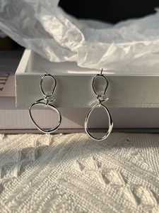 Detail of handcrafted 925 sterling silver interlocking knot earrings with polished finish