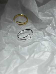 Close-up of dual-line irregular wavy open rings in gold and silver finish